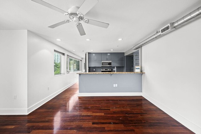 kitchen featuring a peninsula, baseboards, modern cabinets, gray cabinetry, and stainless steel appliances