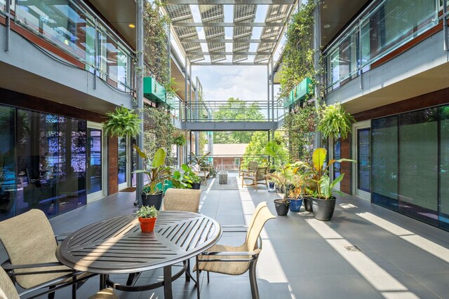 exterior space with a sunroom, outdoor dining area, and a patio area
