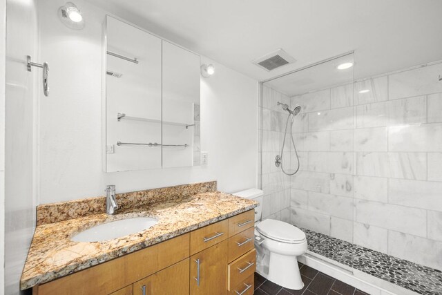 full bath with visible vents, vanity, toilet, recessed lighting, and a tile shower