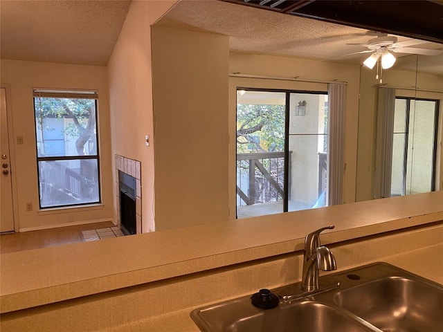 kitchen featuring a sink, a textured ceiling, ceiling fan, and light countertops