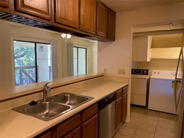 kitchen featuring separate washer and dryer, a sink, dishwasher, and light countertops