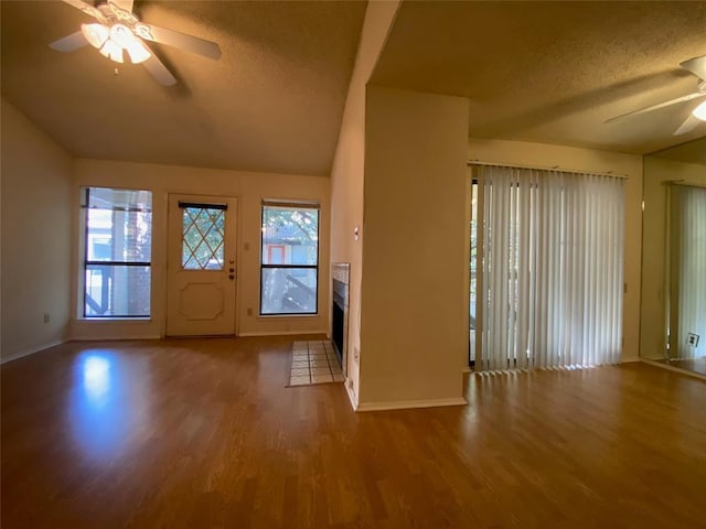 foyer with baseboards, ceiling fan, a textured ceiling, and wood finished floors