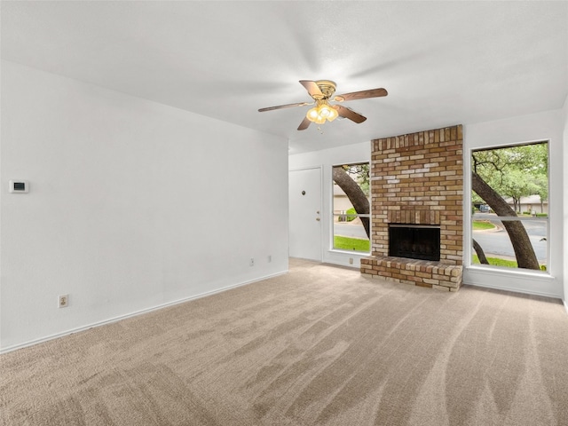 unfurnished living room featuring carpet floors, a ceiling fan, baseboards, and a fireplace