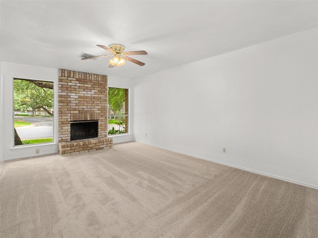 unfurnished living room featuring visible vents, a ceiling fan, carpet, and a brick fireplace