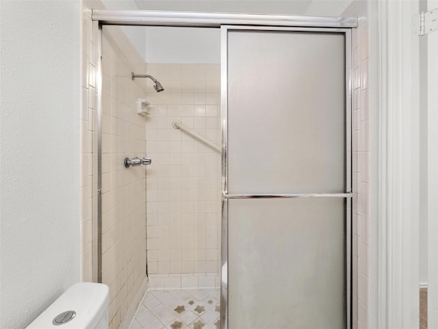 bathroom featuring a stall shower and toilet