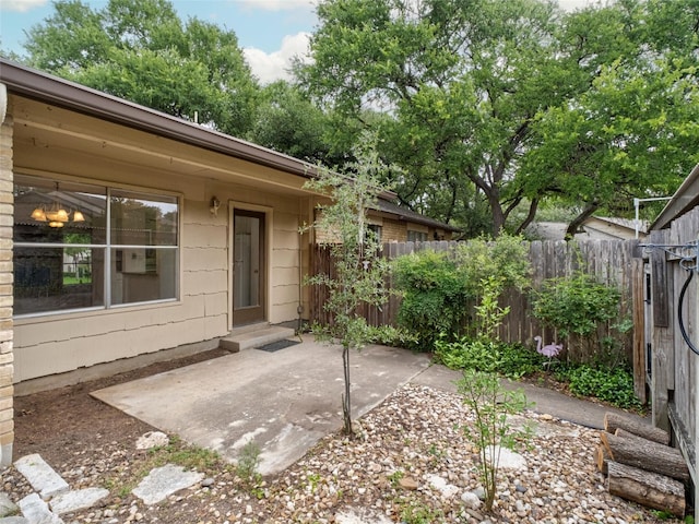 entrance to property featuring a patio area and fence