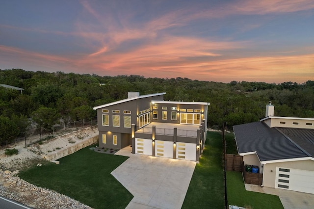 3503 Constitution Dr, Lago Vista, TX 78645 - view of front of house with concrete driveway, a balcony, a wooded view, and an attached garage