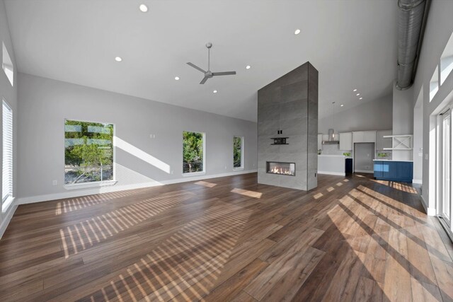 3503 Constitution Dr, Lago Vista, TX 78645 - unfurnished living room featuring high vaulted ceiling, a ceiling fan, wood finished floors, a tile fireplace, and recessed lighting