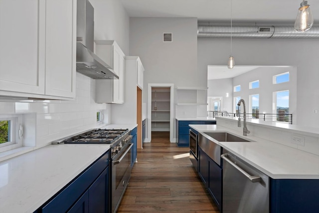 3503 Constitution Dr, Lago Vista, TX 78645 - kitchen featuring wall chimney exhaust hood, stainless steel appliances, blue cabinets, dark wood-style floors, and white cabinets