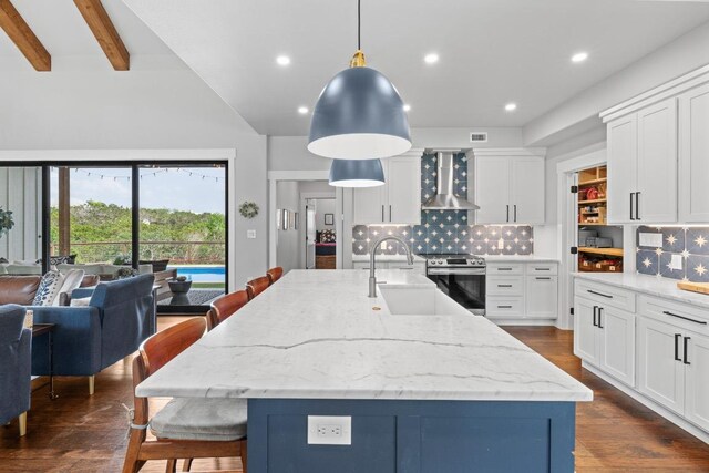 kitchen with white cabinets, stainless steel electric range, a kitchen breakfast bar, wall chimney exhaust hood, and backsplash