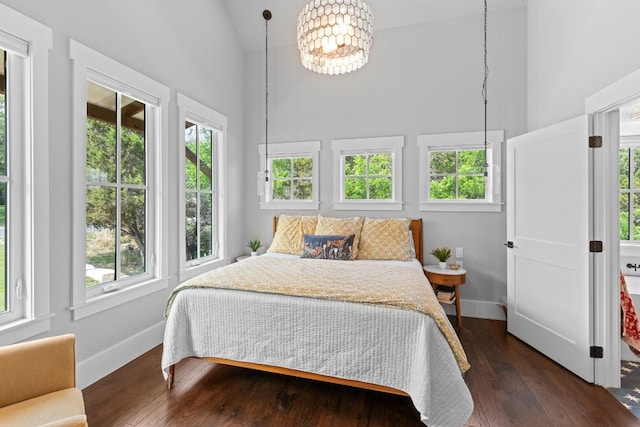 bedroom featuring dark wood-style flooring, high vaulted ceiling, a chandelier, and baseboards