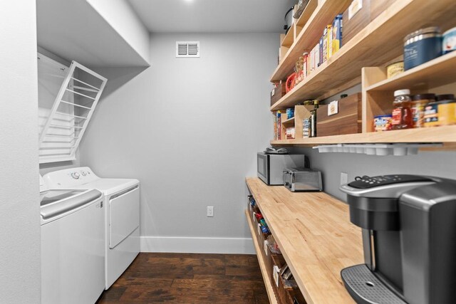 laundry room with laundry area, baseboards, dark wood-type flooring, visible vents, and washer and clothes dryer