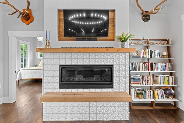 room details featuring baseboards, wood finished floors, and a fireplace