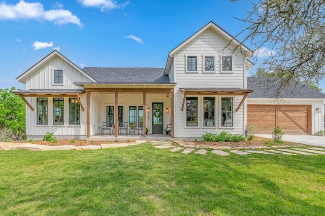 view of front facade featuring board and batten siding, roof with shingles, driveway, and a front yard