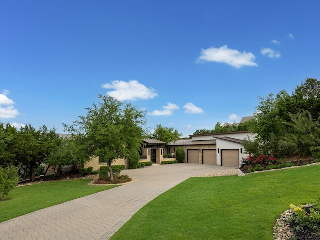 view of front facade featuring an attached garage, decorative driveway, a front lawn, and stucco siding