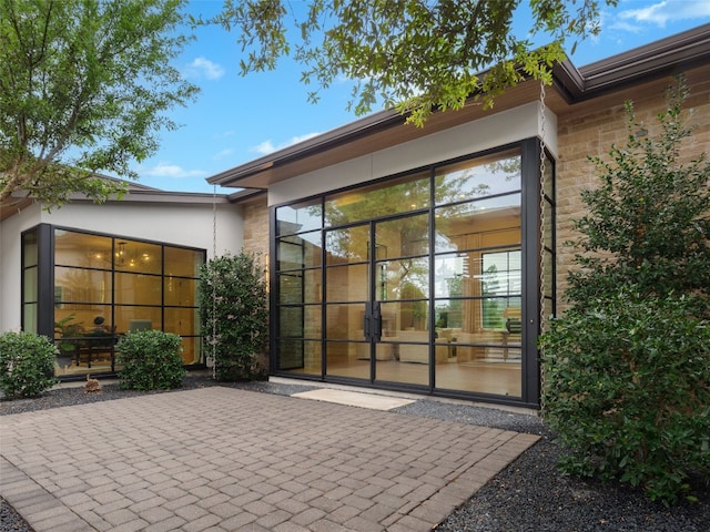 rear view of house with a patio and stucco siding