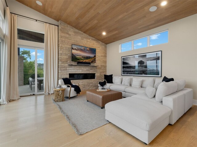 living area with a healthy amount of sunlight, high vaulted ceiling, recessed lighting, and a stone fireplace