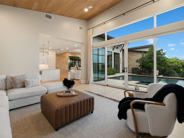 living area featuring recessed lighting, wood ceiling, a towering ceiling, and visible vents