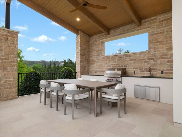 view of patio with ceiling fan, a sink, a grill, area for grilling, and outdoor dining space