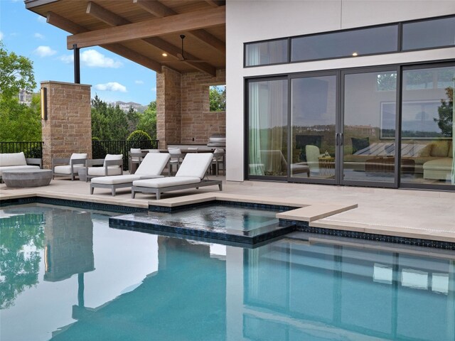 view of pool featuring a patio, a pool with connected hot tub, and fence