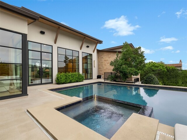view of swimming pool featuring a patio and a pool with connected hot tub
