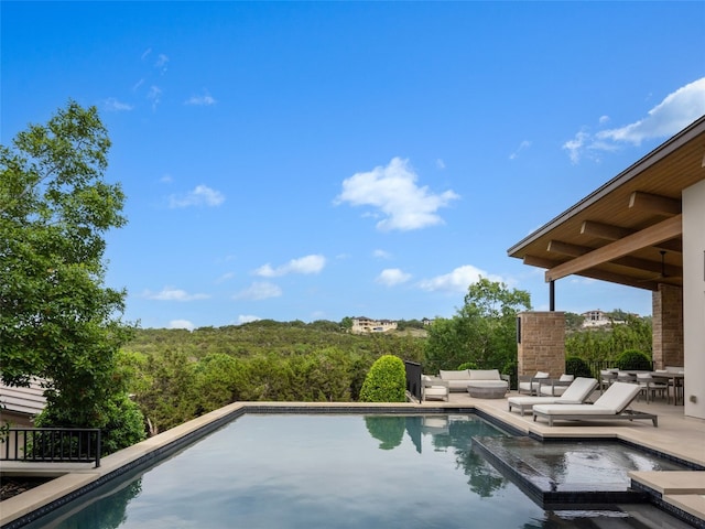 view of swimming pool with a pool with connected hot tub, an outdoor living space, and a patio area