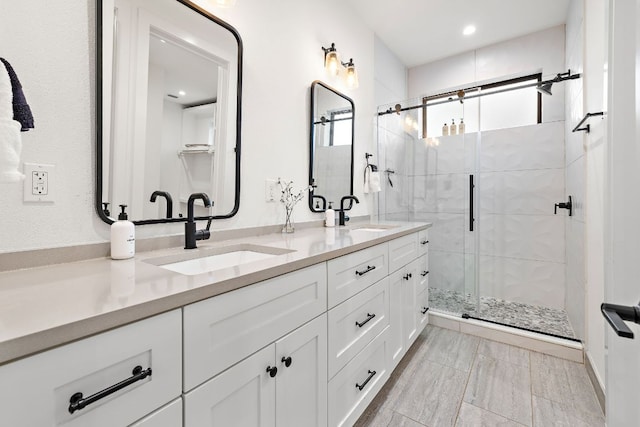 full bathroom with double vanity, recessed lighting, a shower stall, and a sink