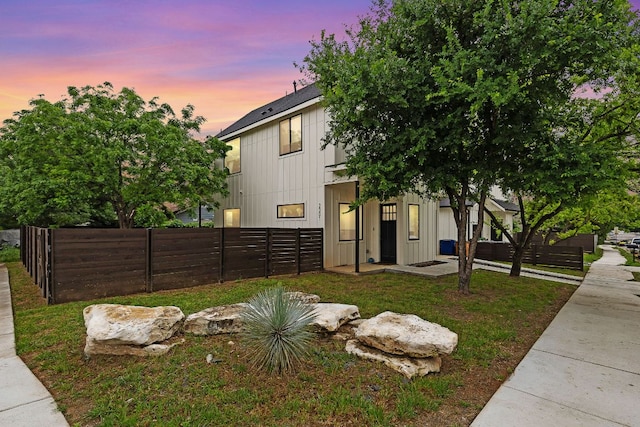view of front of property featuring board and batten siding and fence private yard