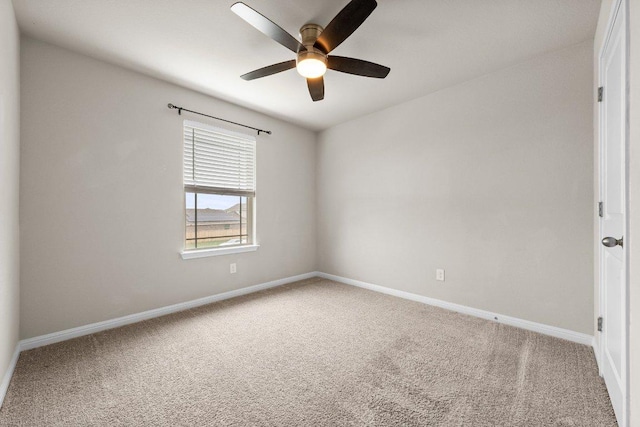 carpeted spare room with baseboards and ceiling fan