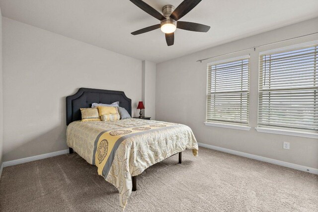 carpeted bedroom featuring baseboards and ceiling fan