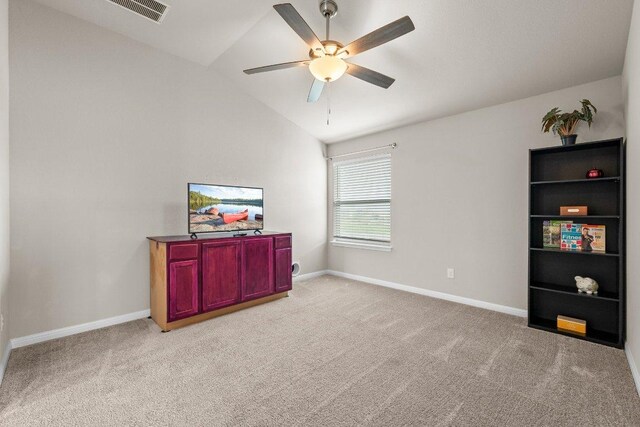 interior space with visible vents, baseboards, light colored carpet, a ceiling fan, and vaulted ceiling