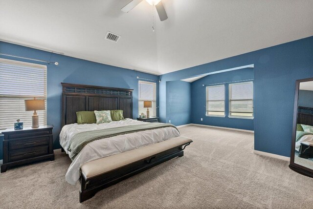 bedroom with visible vents, carpet floors, baseboards, ceiling fan, and vaulted ceiling
