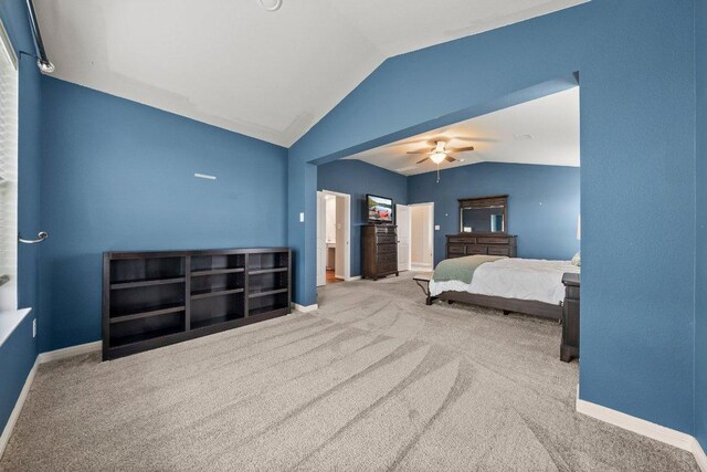 carpeted bedroom with baseboards, ceiling fan, and vaulted ceiling