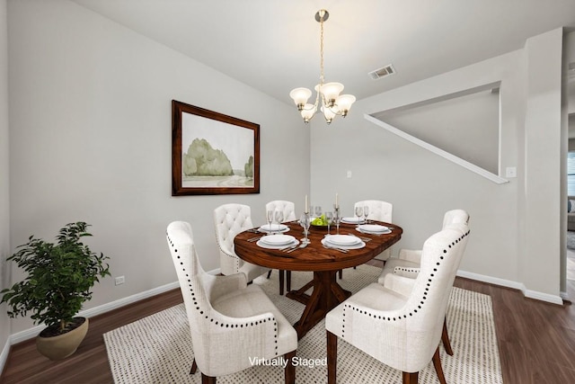 dining space featuring baseboards, a notable chandelier, visible vents, and wood finished floors