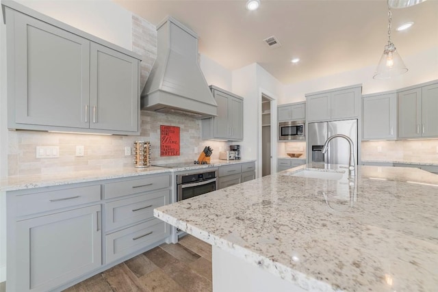 2228 Williams Lakeshore Dr, Kingsland, TX 78639 - kitchen featuring gray cabinets, stainless steel appliances, custom range hood, backsplash, and visible vents