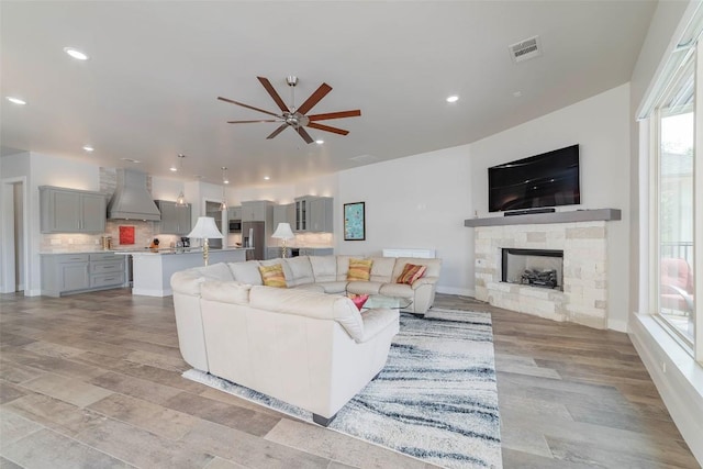 2228 Williams Lakeshore Dr, Kingsland, TX 78639 - living room featuring a ceiling fan, a stone fireplace, visible vents, light wood-style floors, and recessed lighting