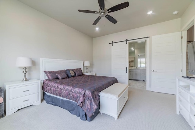 2228 Williams Lakeshore Dr, Kingsland, TX 78639 - bedroom with light colored carpet, a barn door, ensuite bath, and recessed lighting