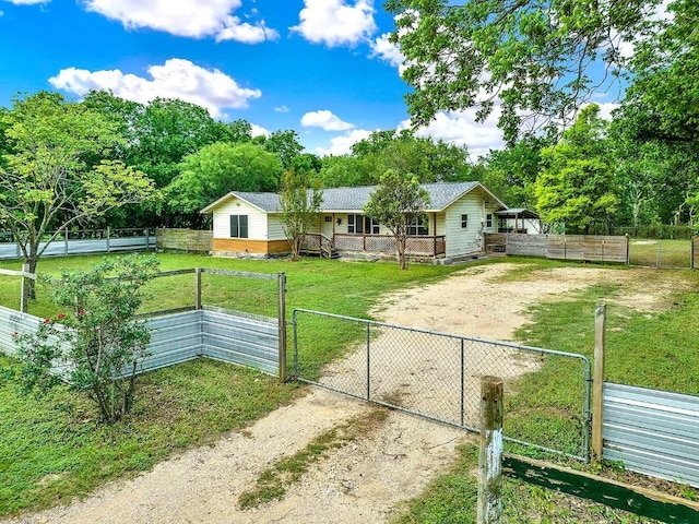 view of front of home with fence private yard, a front yard, dirt driveway, a gate, and a porch