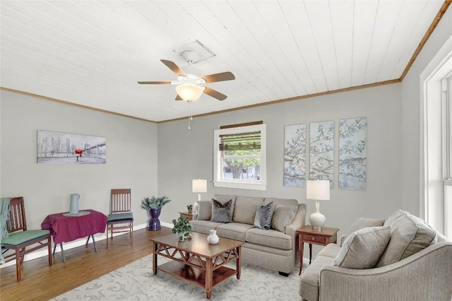 living room with crown molding, ceiling fan, light wood-style floors, baseboards, and wood ceiling
