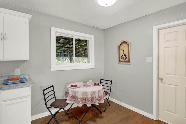 dining area with baseboards and wood finished floors