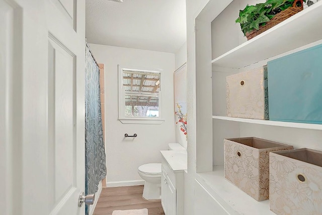 full bathroom with vanity, baseboards, wood finished floors, and toilet