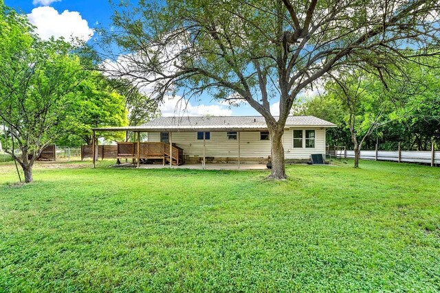 rear view of property with fence, a patio, a yard, and a deck