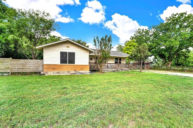 back of property with a lawn, brick siding, and fence