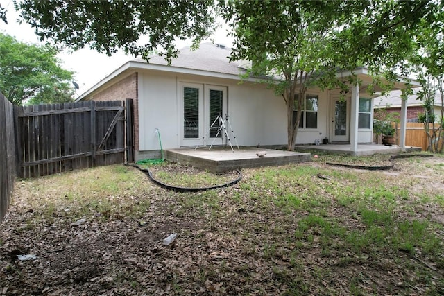 rear view of house with a fenced backyard and a patio area