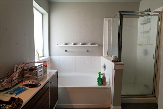 bathroom featuring a healthy amount of sunlight, a shower stall, and a garden tub