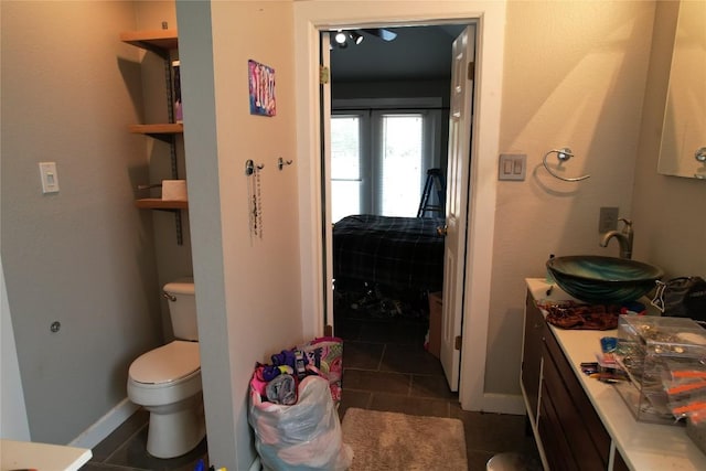 bathroom with vanity, baseboards, tile patterned floors, and toilet