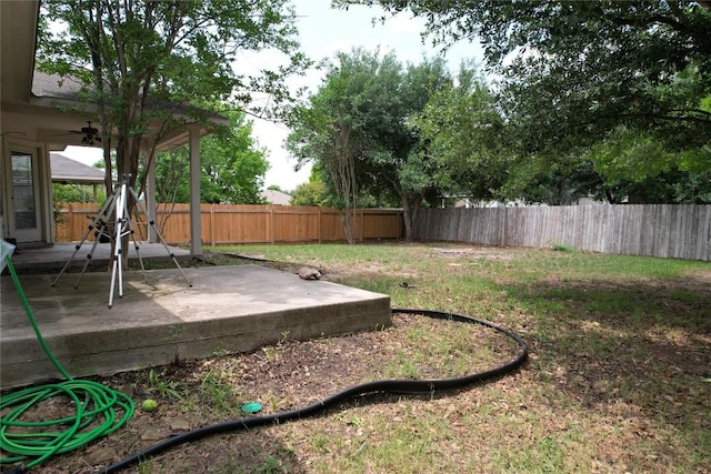 view of yard featuring a fenced backyard, a ceiling fan, and a patio area