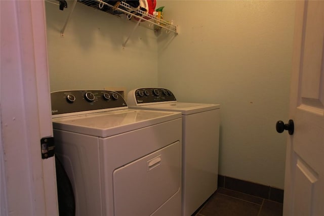 laundry room featuring laundry area, dark tile patterned floors, and washing machine and clothes dryer