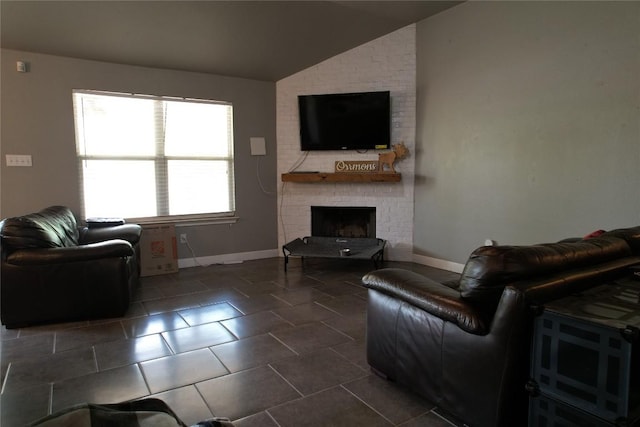 living room with a brick fireplace, dark tile patterned floors, baseboards, and lofted ceiling