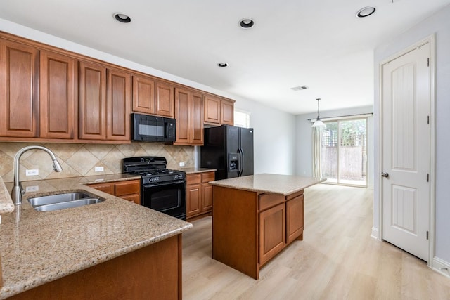 kitchen featuring a sink, black appliances, and brown cabinets